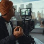 Cameraman filmt door een zoeker een onscherp stadsbeeld