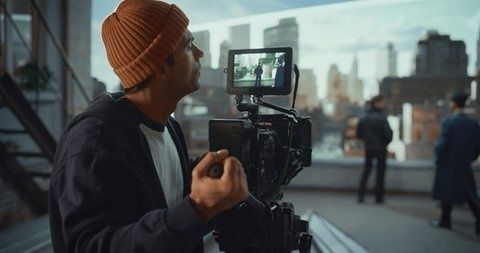 Cameraman filmt door een zoeker een onscherp stadsbeeld